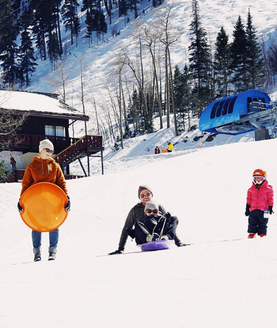 Family enjoying the sledding hill at Taos Ski Valley.