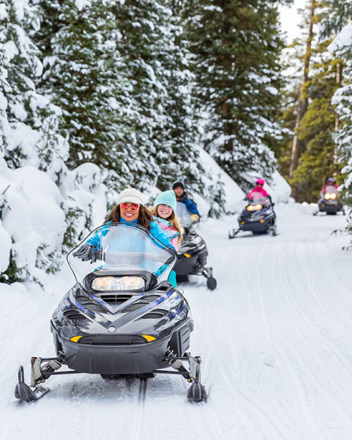 A group of snowmobilers on a guided tour.