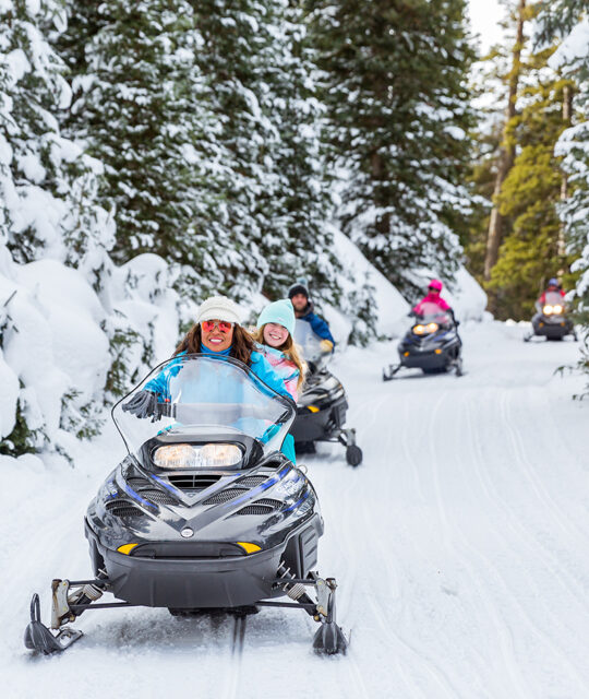 A group of snowmobilers on a guided tour.