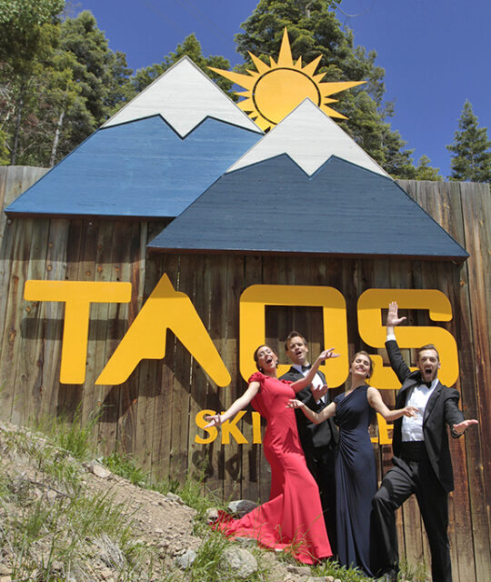 Opera singers in front of the Taos resort sign