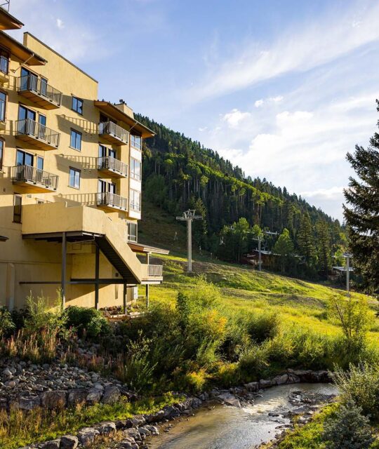 Summer on the Rio Condo with a view of the lodge to the green mountains.