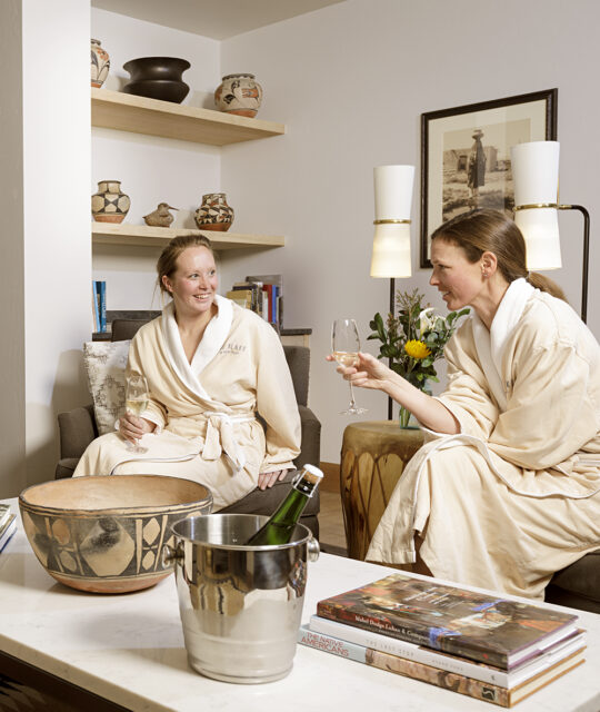 Women waiting for their spa treatments wearing robes and sipping champagne