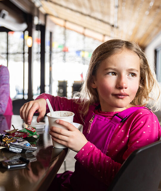 Girl enjoying a ski break snack