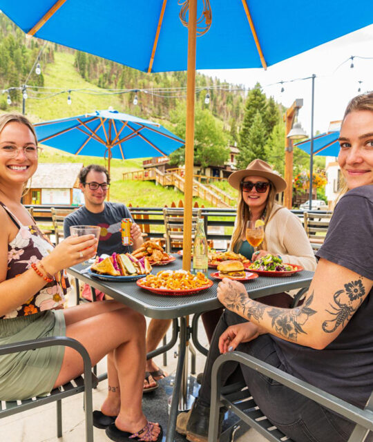 Young diners enjoying food and drinks on an outdoor patios