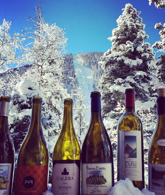 Wine bottles with Taos Al's Run in the background.