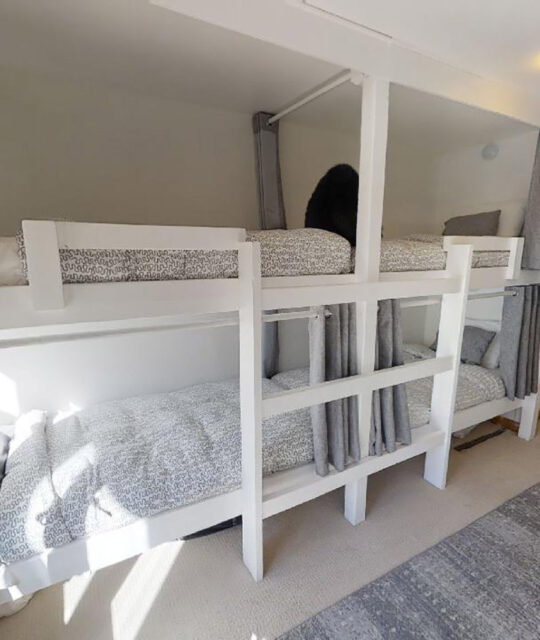 Kid's bunk room with four bunks with curtains