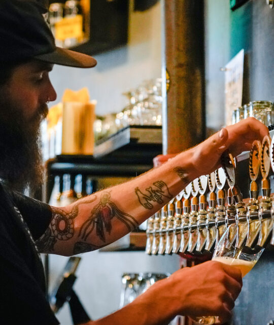 Bartender drafting a pint of beer