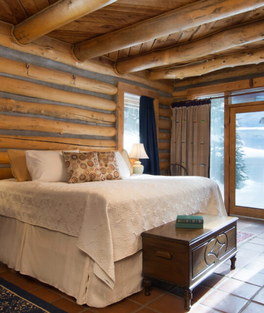 Bright bedroom in a log home in the snowy mountains