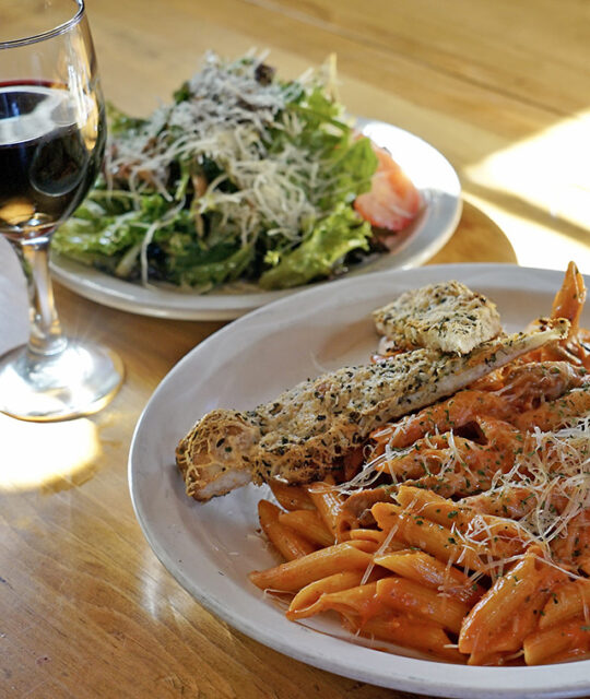 Pizanos pasta, bread, salad and glass of wine