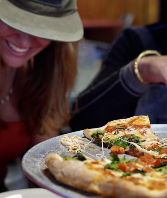 Laughing young couple enjoying pizza