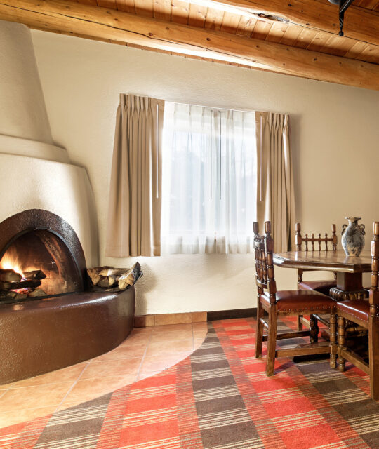 Hotel room with kiva fireplace and table