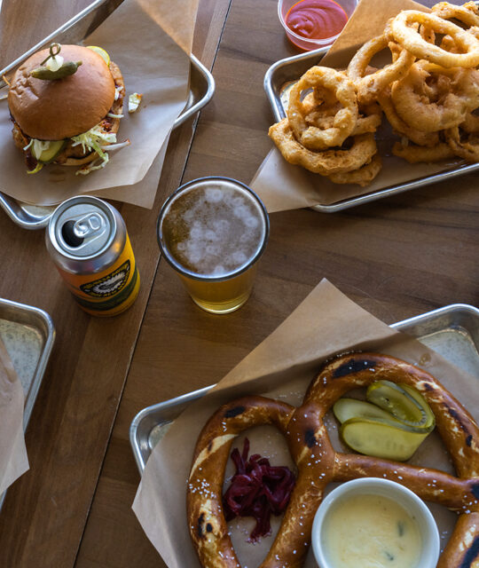 Onion rings, giant pretzel, burger, and IPA