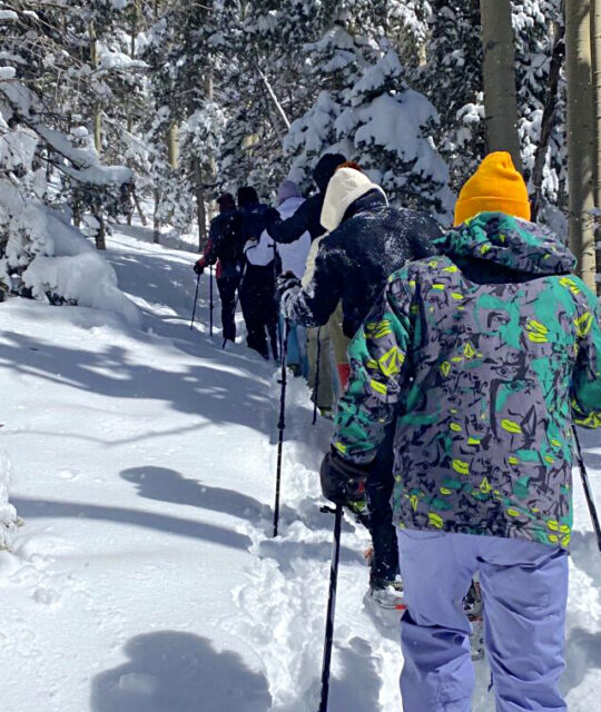 Group of snowshoers heading up a trail