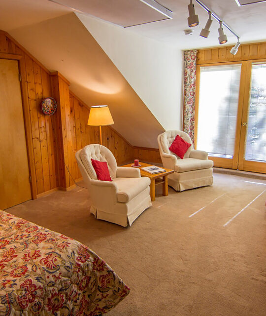 Sitting chairs in chalet bedroom with balcony