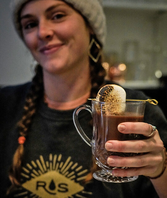 Cute bartender serving hot coco at The Lounge by Rolling Still Distillery