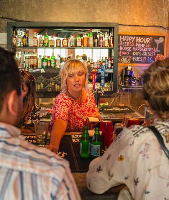 Server behind the bar serving drinks.