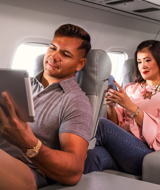 Passengers in airline using devices inflight.