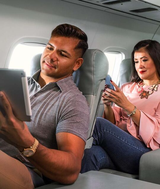 Passengers in airline using devices inflight.