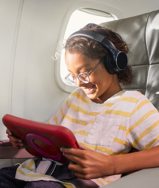Child watching a video on tablet in airplane.