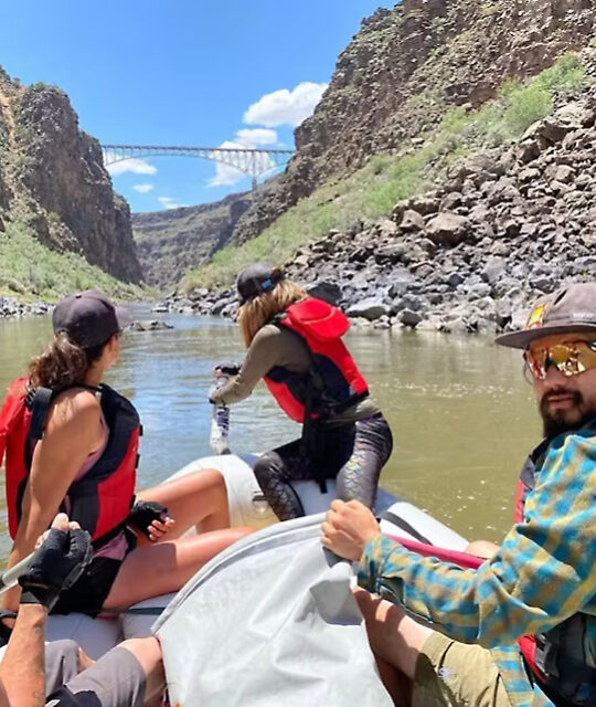 Rafters on a scenic float trip passing under the Rio Grande Gorge Bridge.