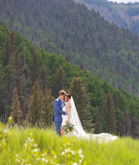 Bride and groom in a beautiful mountain meadow.