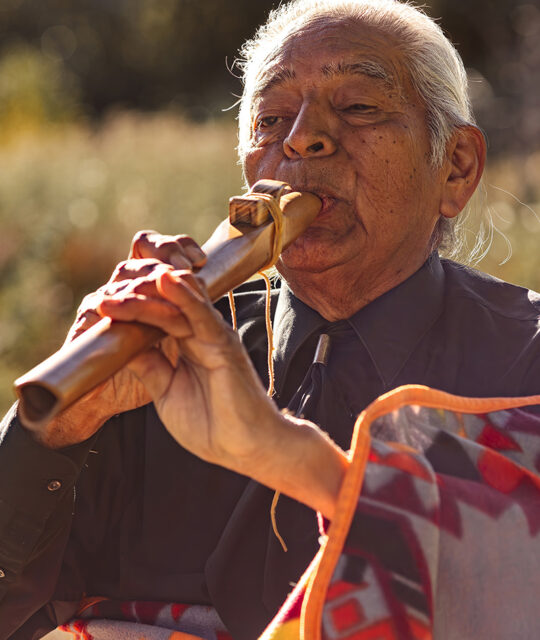 Native elder flute player.