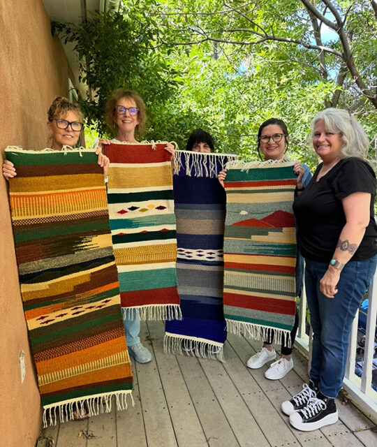 Weavers showing off their rugs.