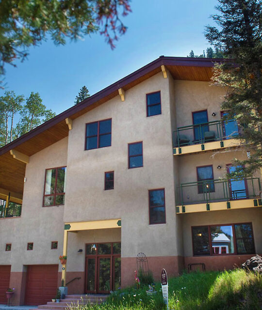 A large, modern mountain chalet in summer