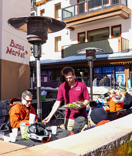 Skiers dining at outdoor patio.