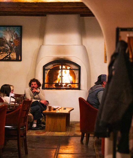 Guests enjoying apres by the fire at Saltos in Arroyo Seco.