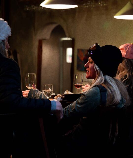 Women enjoying wine at the bar at Saltos.