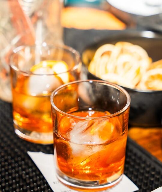 Two cocktails ready to serve at a bar.