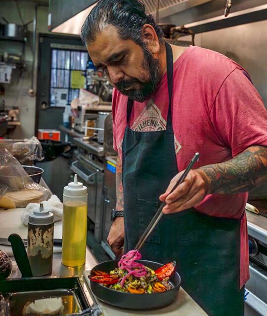 Chef preparing mushroom chimichurri dish.