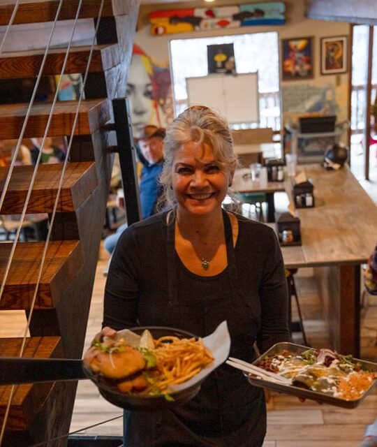 Server holding plates of food at DALEEE TSV in Taos Ski Valley.
