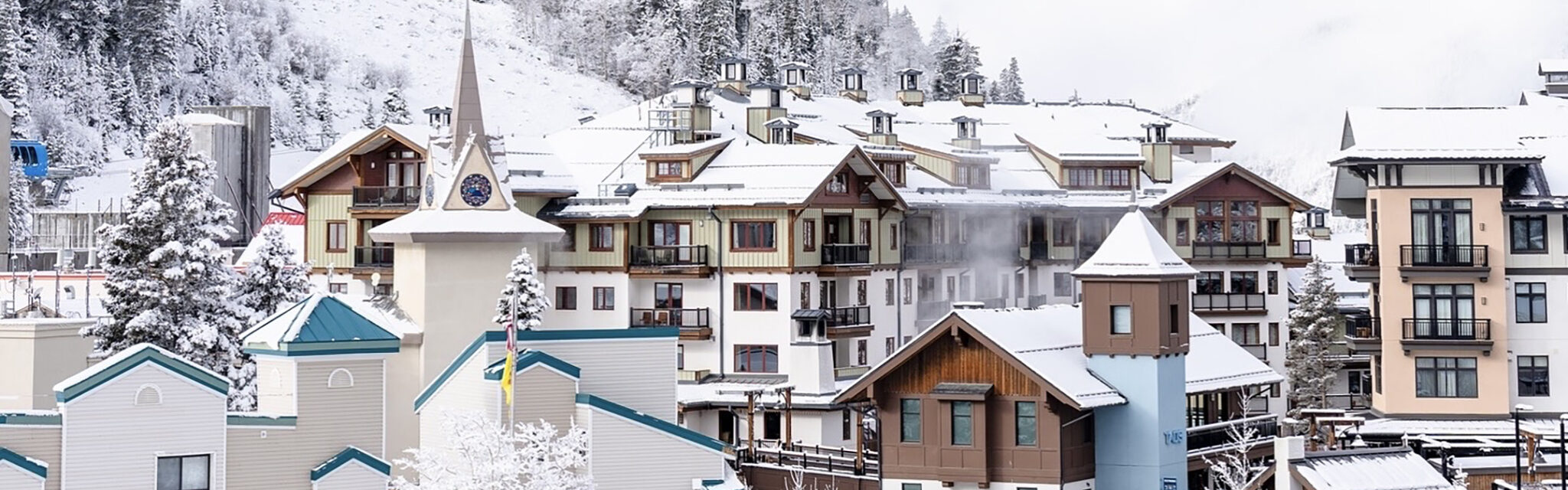A cluster of buildings in a mountain village sit in a snowy valley.