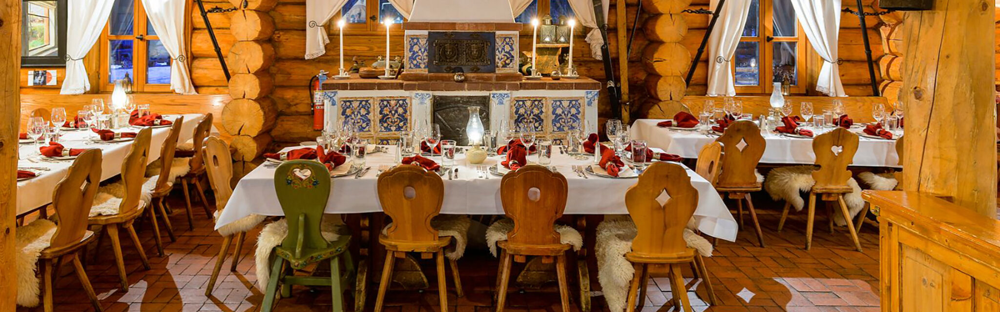 An empty German restaurant in a log cabin with set tables.