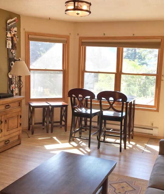 Bright afternoon sun coming into the windows and breakfast nook table and chairs.