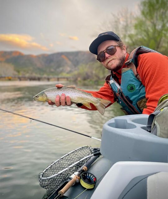 Man showing his catch on a float boat fly fishing trip.