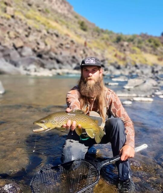A man showing his trout catch on the Rio Grande river.
