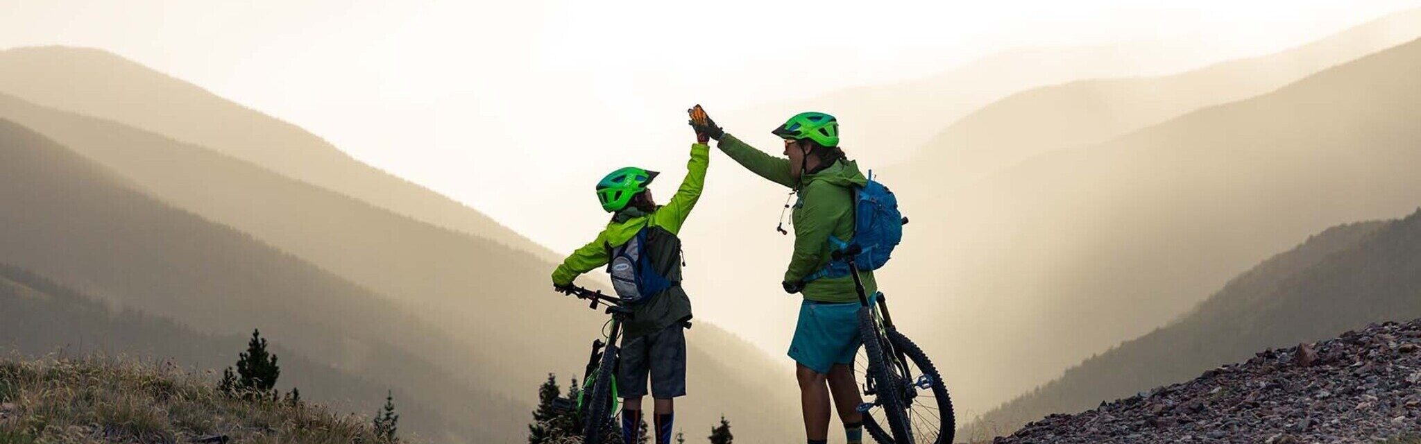 2 people on bikes giving a high five to each other
