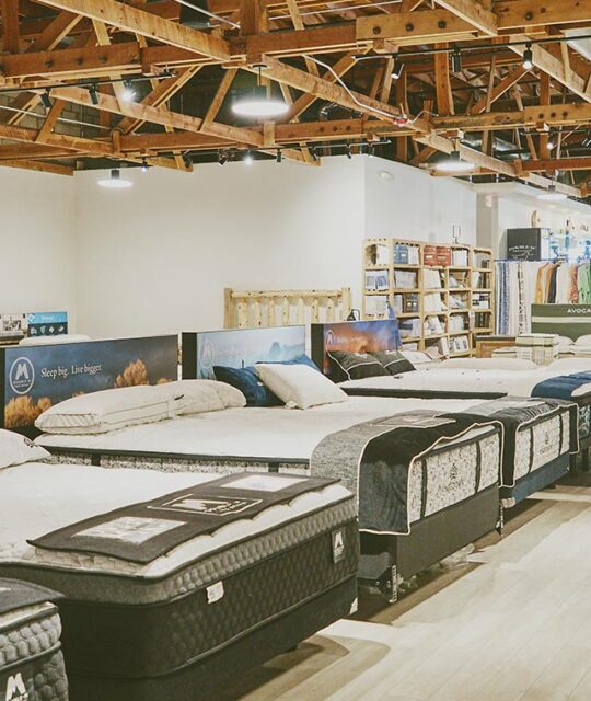 Inside a mattress store with displays of mattresses..