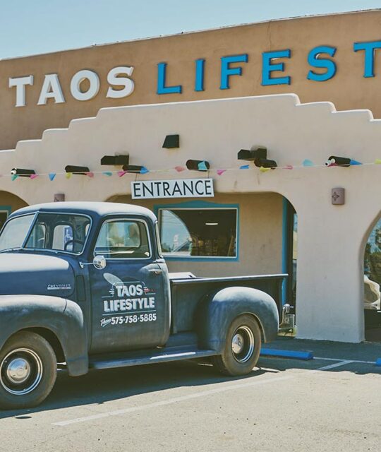 Entrance to Taos Lifestyle with an old truck parked in front.